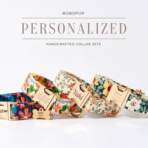 Pode incluir: Quatro conjuntos de coleiras para cães personalizadas com padrões florais. Cada coleira apresenta uma fivela dourada e uma etiqueta a condizer com um nome e informações de contacto. As coleiras são em tons de azul, amarelo e creme.