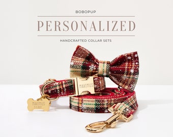 May include: Red and green plaid dog collar and leash set with a matching bow tie. The collar has a gold buckle with the name "MAXIMUS" engraved on it. The leash has a gold hook. The bow tie has a snowflake pattern. The tag on the collar says "MAXIMUS 9-3-2023".