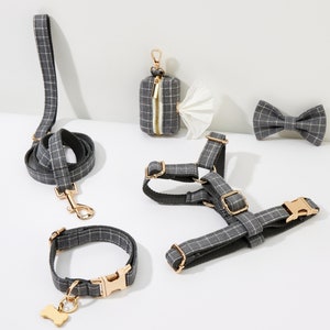 May include: A set of dog accessories in a gray and white plaid pattern. The set includes a leash, collar, harness, and bow tie. The accessories are all made of a soft, durable fabric and feature gold-tone hardware.
