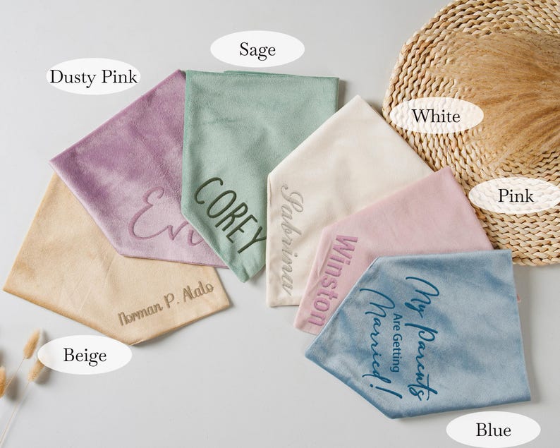 Puede incluir: Un surtido de pa&ntilde;uelos personalizados en varios colores, incluyendo rosa empolvado, verde salvia, beige, blanco, rosa y azul. Cada pa&ntilde;uelo presenta texto bordado, con nombres y frases como "My Parents Are Getting Married!"
