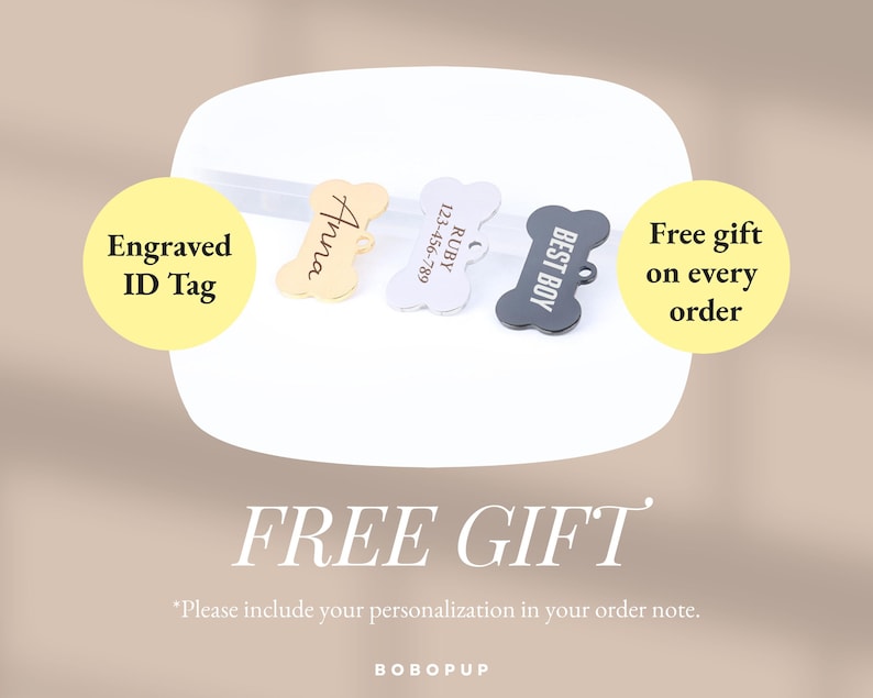 May include: Three dog bone-shaped engraved ID tags. The tags are gold, silver, and black. The gold tag says "Anna", the silver tag says "RUBY 123-456-789", and the black tag says "BEST BOY". The text "Engraved ID Tag" is in a yellow circle on the left side of the image. The text "Free gift on every order" is in a yellow circle on the right side of the image. The text "FREE GIFT" is in large letters below the tags. The text "*Please include your personalization in your order note." is below the large text. The text "BOBOPUP" is at the bottom of the image.