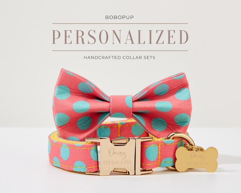 May include: A pink and blue polka dot dog collar and bow tie set with a gold buckle and bone tag. The tag is engraved with the name "Daisy" and a phone number. The set is handcrafted and personalized.