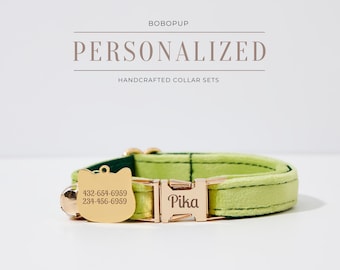 May include: A green velvet cat collar with a gold buckle and a gold cat-shaped tag engraved with the name "Pika" and phone numbers "432-654-6959" and "234-456-6959".