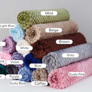 May include: A stack of 12 plush blankets in various colors, including mint, beige, brown, grey, dusty pink, coffee, light blue, lilac, white, baby pink, violet, blue, green, purple, and dusty blue.
