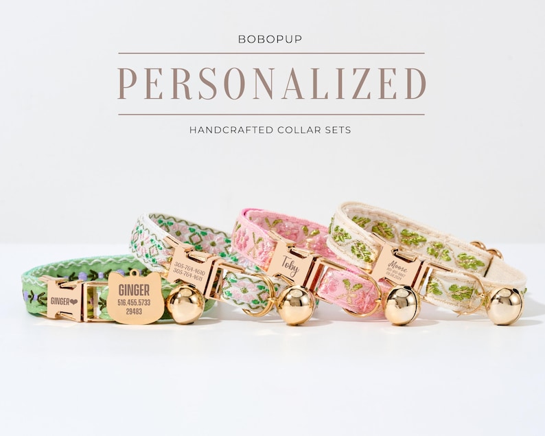 May include: Three personalized cat collars with embroidered floral patterns and gold-tone hardware. The collars are in green, pink, and white with gold-tone bells. Each collar has a personalized name tag with the names "Ginger", "Toby", and "Alice".