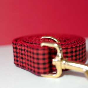 May include: Red and black checkered dog leash with a gold metal clasp.