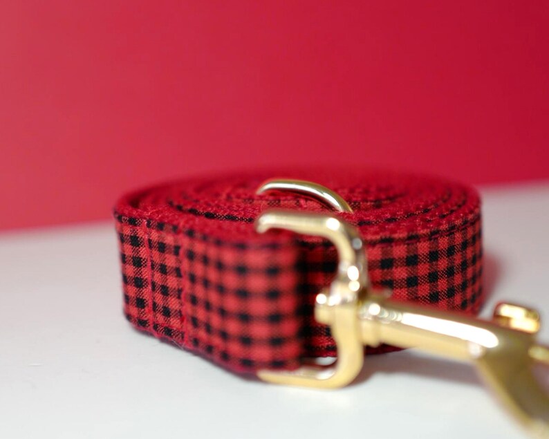 May include: Red and black checkered dog leash with a gold metal clasp.