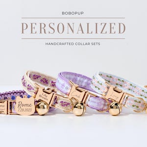 May include: Three personalized cat collars with gold-tone buckles and bells. The collars are decorated with floral patterns in shades of purple and white. The name tags read "Rome", "Lily Brown", and "Cade".