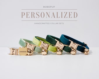 May include: Four personalized cat collar sets in white, light green, dark green, and teal. Each collar has a gold-colored buckle and a matching tag with a cat face shape. The tags are engraved with a name and phone number. The text "BOBOPUP" and "PERSONALIZED HANDCRAFTED COLLAR SETS" are at the top.
