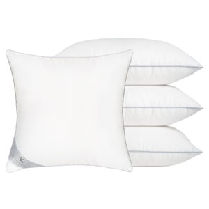 May include: Four white pillows with a gray trim stacked on top of each other. The pillow on the bottom has a silver label with the text "Dream Weaver" on it.