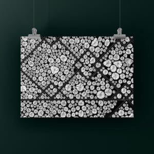 May include: A rectangular wall art print featuring a black and white graphic pattern of numerous circular cross-sections of wood logs arranged within a geometric grid of thin black lines, suspended by two silver metal clips at the top edge.