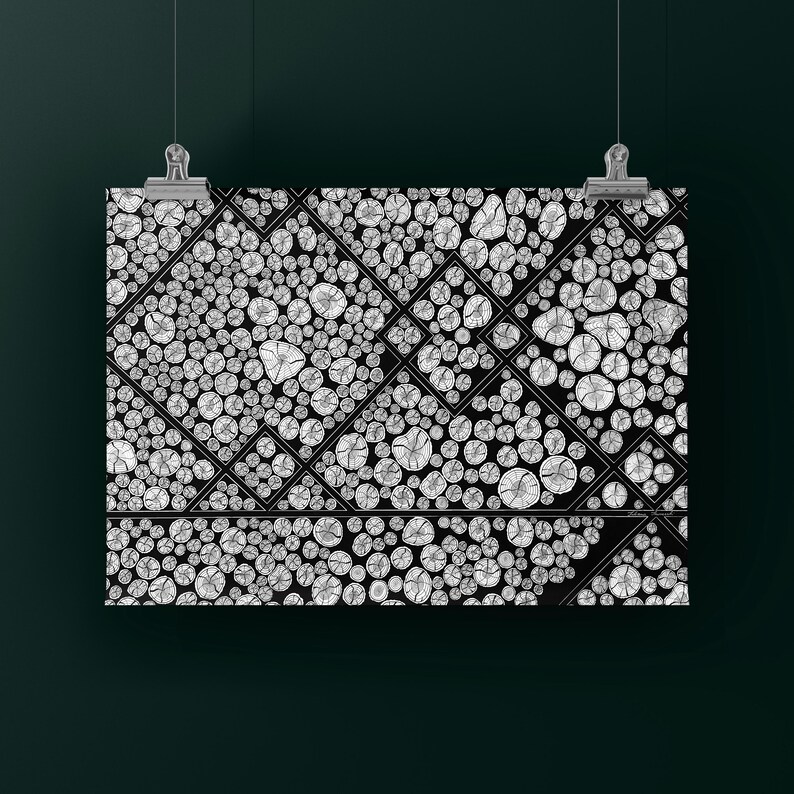 May include: A rectangular wall art print featuring a black and white graphic pattern of numerous circular cross-sections of wood logs arranged within a geometric grid of thin black lines, suspended by two silver metal clips at the top edge.