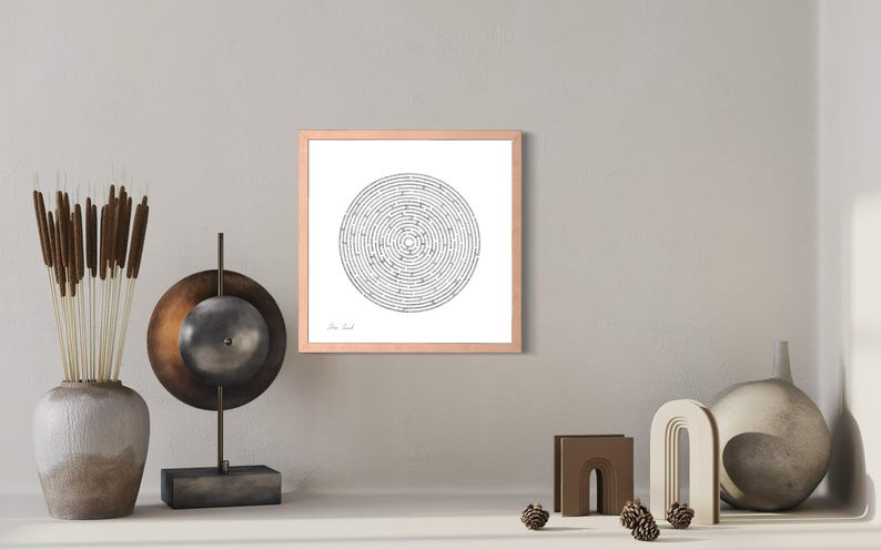 May include: A square framed wall art piece featuring a black and white circular maze design on a white background. The frame is a light wood tone. The maze consists of concentric rings with a clear start and end point, centred within the frame.