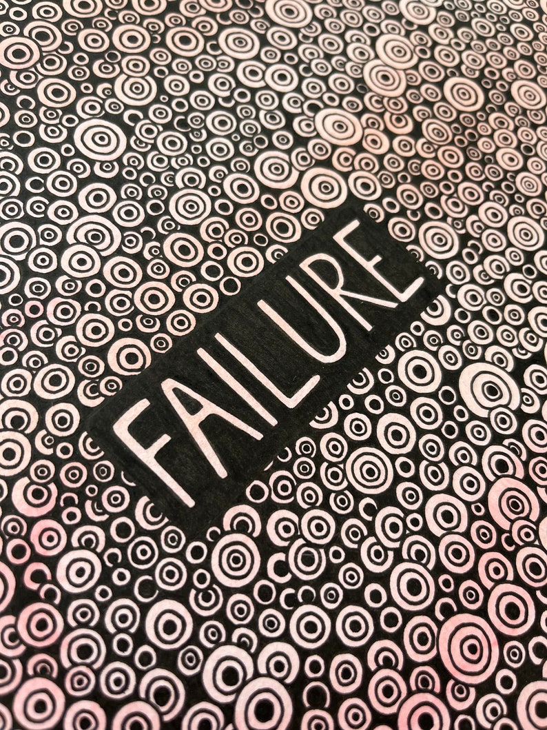May include: Black and white background with a pattern of concentric circles in shades of pink. The word "FAILURE" is written in white letters on a black rectangle.