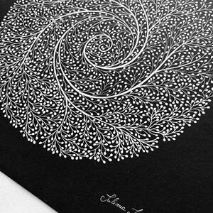 May include: A square black print featuring a white circular spiral design composed of intricate, branching, vine-like patterns with small rounded buds. The artist's signature, Juliana Iavorschi, is printed in white cursive in the bottom right corner.