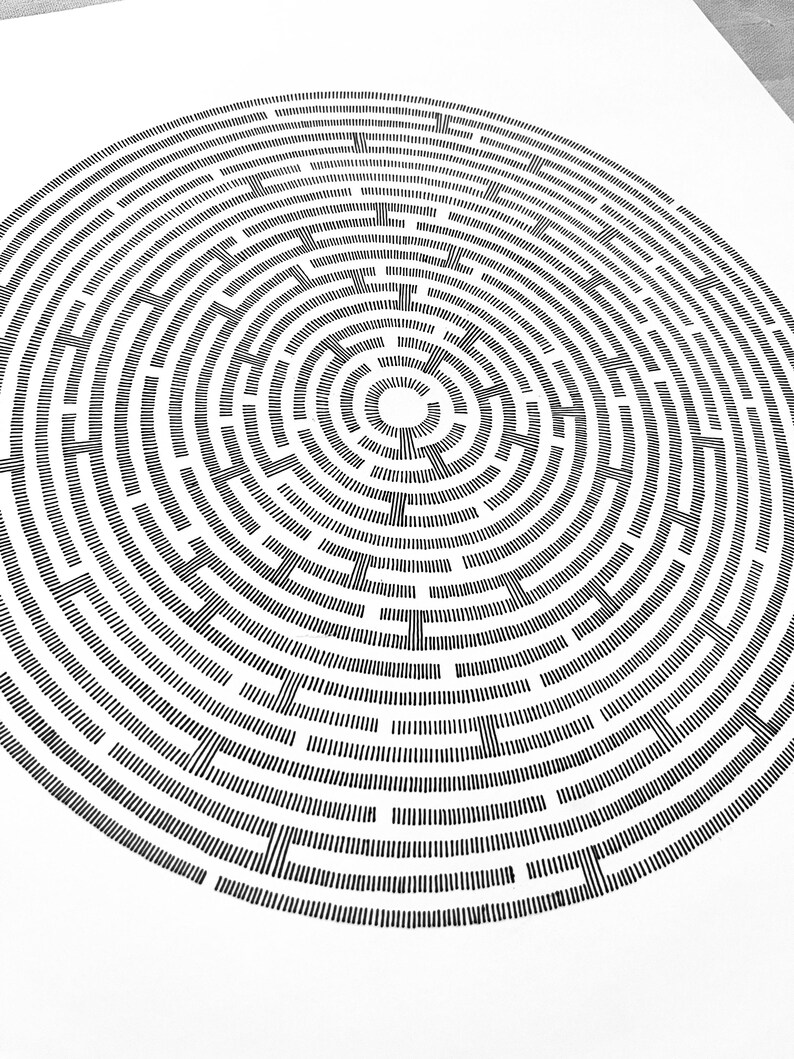 May include: A circular maze illustration composed of black ink lines on a white background. The design features concentric rings of short, vertical dashes separated by gaps, creating a complex path structure that radiates from a central white circle.