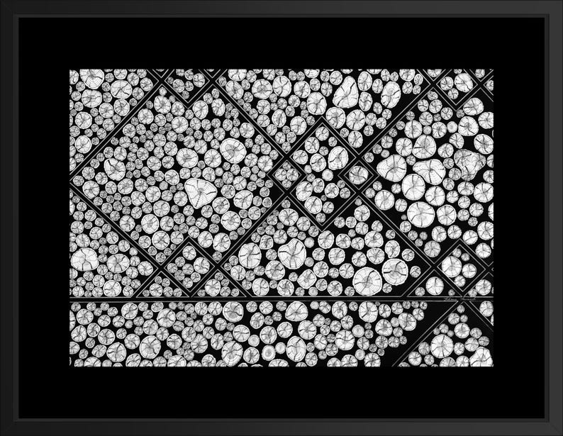 May include: A black and white framed print featuring a geometric pattern composed of numerous circular cross-sections of wood logs. The circular shapes are arranged within a series of intersecting diamond and triangular outlines, creating a structured, repeating visual composition.