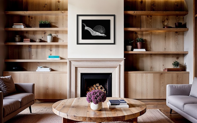 May include: A framed black and white art print featuring a stylised snail illustration with a circular shell pattern, displayed on a wall above a fireplace. The artwork is enclosed in a simple black frame with a white mat border, centred on the wall.