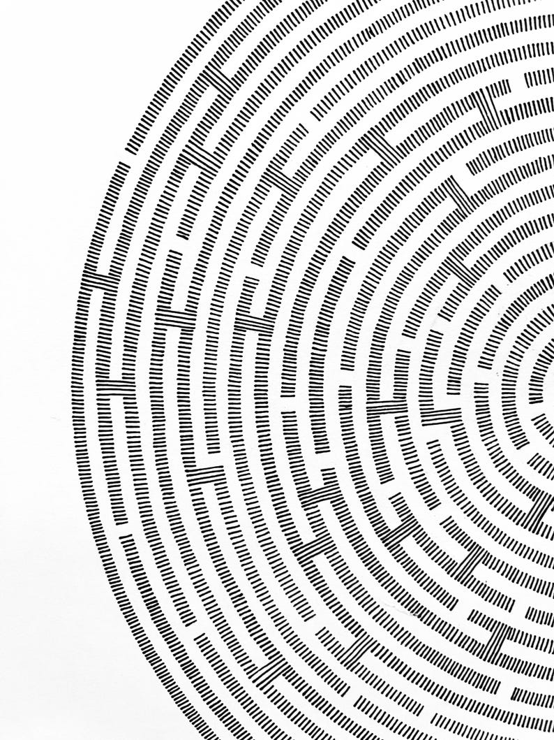 May include: A circular maze pattern composed of black ink lines on a white background. The design features concentric rings interrupted by vertical segments, creating a complex path structure that radiates from the centre towards the outer edge.