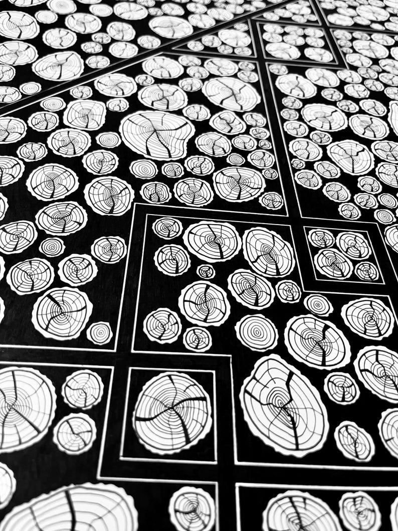 May include: A black and white graphic illustration featuring a repeating pattern of circular tree ring cross-sections. The design is organized into geometric segments separated by thin white lines, creating a structured grid of organic wood grain motifs.