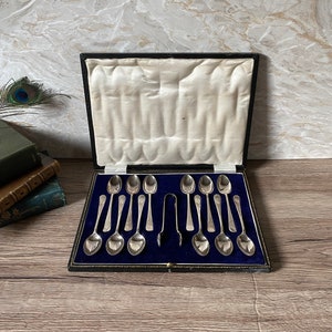 Vintage boxed set of 12 silver plated teaspoons and matching sugar tong, with swirling decoration / boxed set of afternoon tea spoons