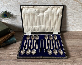 Vintage Boxed Set aus 12 versilberten Teelöffeln und passender Zuckerzange, mit wirbelnder Dekoration / boxed Set Nachmittagsteelöffel