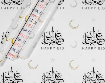Könnte beinhalten: Weißes Geschenkpapier mit einem sich wiederholenden Muster aus goldenen Halbmonden, Sternen und dem arabischen Satz "Eid Mubarak" in Schwarz, was "Frohes Eid" bedeutet.