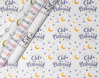 May include: White wrapping paper with a repeating pattern of gold crescent moons, purple stars, and the text "Eid Mubarak" in purple script.