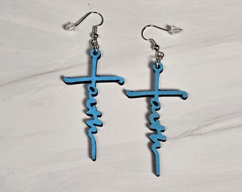 May include: A pair of blue wooden earrings shaped like crosses with the word "faith" written vertically on each cross.