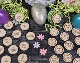 May include: Wooden Easter egg tokens with various activities and rewards written on them, including "Pizza Night", "Sweet Treat", "Go for a Walk", "Movie Night", "Game Night", "Skip Chore", "Day with Dad", "Day with Mom", "No Chores Today", "Build a Fort", "Craft Project", "Family Game Night", "Go Get Ice Cream", "Later Bedtime", "Stay Late", "Go to the Park", "$1", "$2", "$5", and "Surprise".