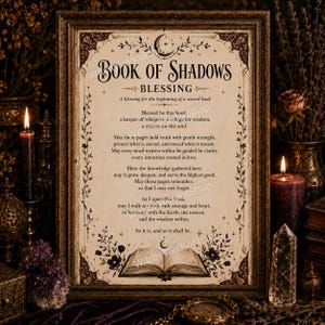 May include: A framed print titled Book of Shadows Blessing, featuring a poem about a sacred book. The text is printed on a cream-colored background with dark brown decorative floral borders, a crescent moon icon, and an illustration of an open book.