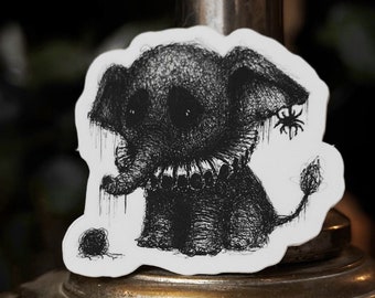 May include: Black and white illustration of a small elephant with a spider on its ear. The elephant is wearing a collar and holding a ball of yarn. The illustration is on a white sticker.