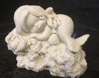 Cute little mermaid ready to paint with seashells