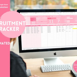 May include: A pink computer screen displaying a Google Sheet spreadsheet with the title "Recruitment Tracker" and the numbers 60, 11, and 7. The text "Automated" is visible below the title. The computer is on a wooden desk with a keyboard and a black mouse.