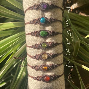 Peut inclure: Sept bracelets en cordon marron avec des perles de pierres précieuses de différentes couleurs. Les perles sont en améthyste, turquoise, aventurine verte, péridot, citrine, cornaline et jaspe rouge. Les bracelets sont numérotés de 1 à 7.