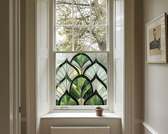 May include: A white window frame with a stained glass window featuring a green and white geometric design. The window is set in a white wall with a white window sill and a white radiator below. A small potted plant sits on the window sill.