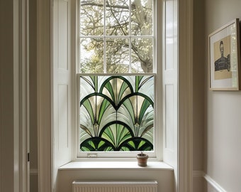 May include: A white window frame with a stained glass window featuring a geometric design of green and gold leaves. A small potted plant sits on the windowsill.