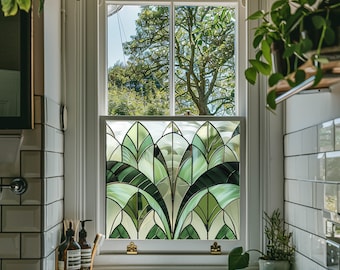May include: A bathroom window with a stained glass window film featuring a green and white geometric design. The window is framed in white and has a white sink below it.