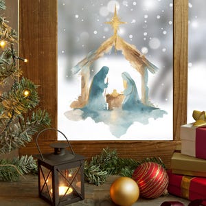 May include: A Christmas-themed still life featuring a watercolor painting of the Nativity scene in a window. A small Christmas tree with lights, a lantern, ornaments, and wrapped gifts complete the festive display. The scene evokes a sense of warmth and holiday cheer.
