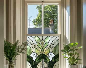 May include: A bathroom window with a stained glass panel featuring a green and white geometric design. The window is framed in white and has a view of a tree and a roof.