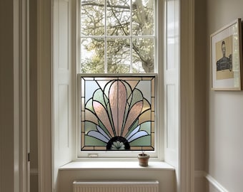 May include: A stained glass window featuring a colourful geometric design in shades of pink, blue, and green. The window is set in a white frame and is surrounded by white trim.
