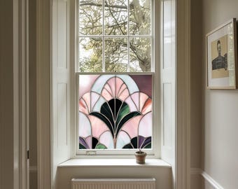 May include: A stained glass window film with a pink, green and purple design. The film is installed in a window with a white frame and a view of trees outside.