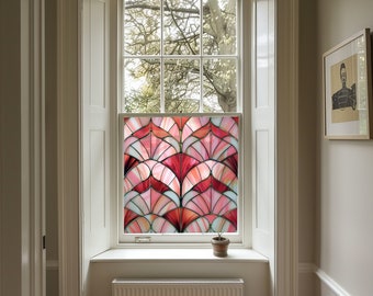 May include: A stained glass window film with a geometric pattern of pink, red, and white. The film is installed on a window in a room with white walls and a white window frame.