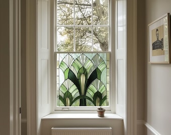 May include: A white window with a stained glass panel featuring a green and white geometric design. The window is framed by white trim and is set in a white wall. A small potted plant sits on the windowsill.