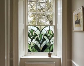 May include: A white window with a stained glass panel featuring a geometric design of green and white leaves. The window is set in a white frame with a white window sill. A small potted plant sits on the window sill.