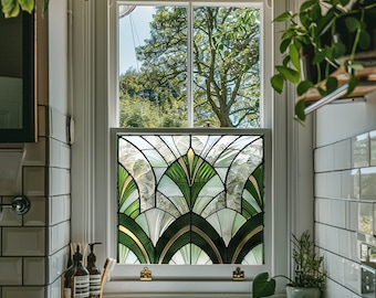 May include: A white bathroom sink with a green and gold stained glass window behind it. The window is framed in white and has a traditional design.