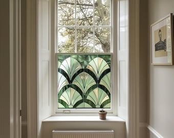 May include: A white window with a stained glass panel featuring a geometric design of green and white leaves. The window is framed by white trim and sits above a white window seat with a small potted plant.