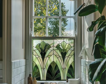 May include: A bathroom with a white tiled wall and a window with a stained glass panel. The stained glass panel features a geometric design with green and white glass. There is a white porcelain sink with a faucet and a shower head in the background.