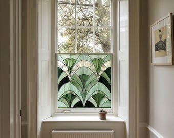 May include: A white window with a stained glass panel featuring a green and white geometric design. The window is framed by white trim and is set in a white wall. A small potted plant sits on the windowsill.