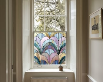 Può includere: Una finestra con un film di vetro colorato che presenta un motivo geometrico di archi e curve in tonalità di blu, viola, rosa e oro. Il film è installato su una finestra in una stanza con pareti bianche e una cornice della finestra bianca.